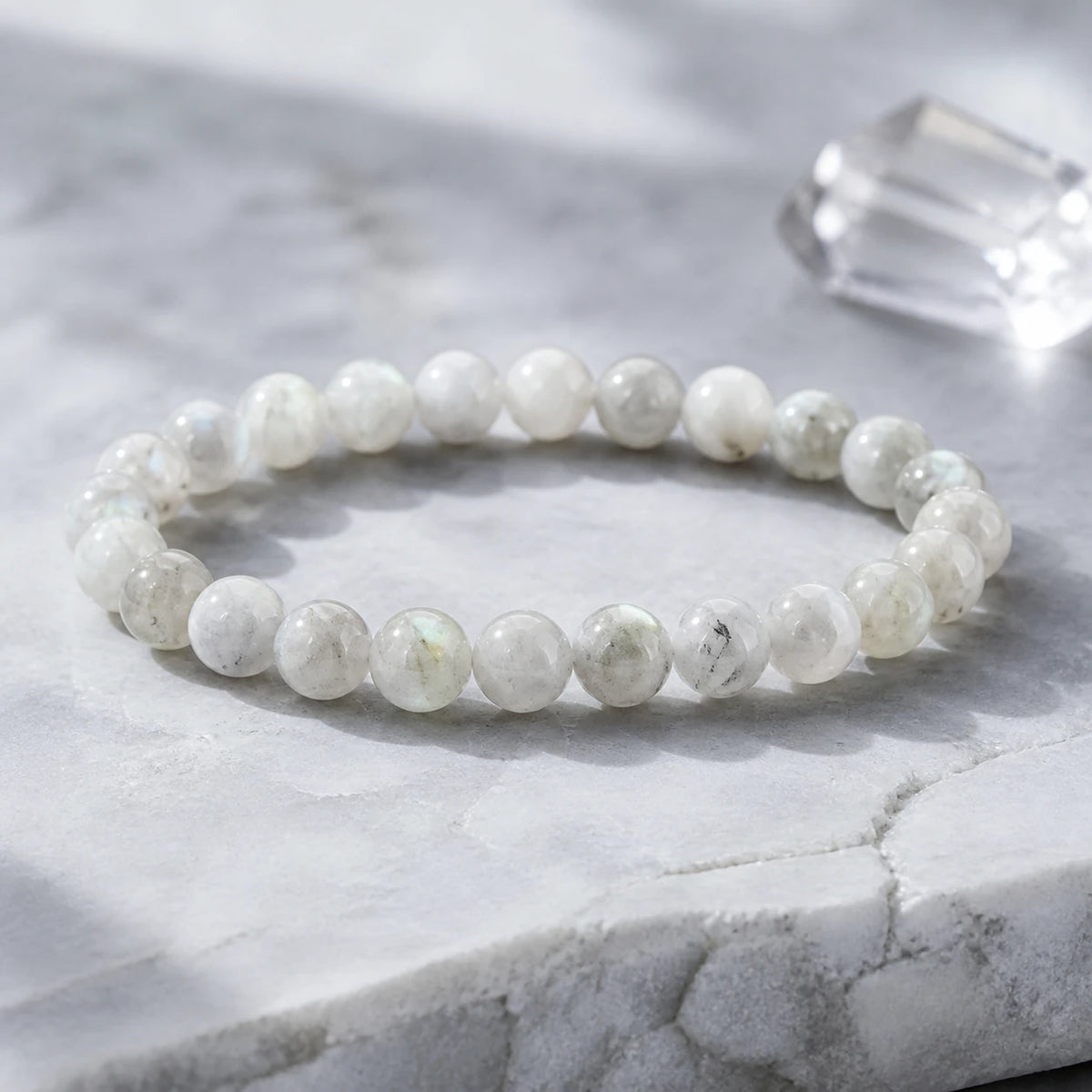 Aurora Flash labradorite bracelet styled in soft moonlight on pale stone