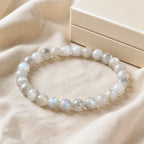 Aurora Flash labradorite bracelet beside an ivory gift box on linen