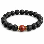 Black lava stone bead bracelet with red center gemstone on white background, minimalist volcanic rock jewelry for grounding and everyday wear.