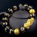 Black Obsidian Pixiu Bracelet displayed with ceramic decor highlighting spiritual craftsmanship.