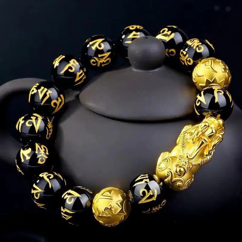 Black Obsidian Pixiu Bracelet displayed with ceramic decor highlighting spiritual craftsmanship.