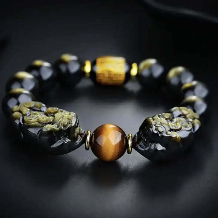 Black obsidian and tiger eye protection bracelet with dual Pixiu charms symbolizing strength and balance.