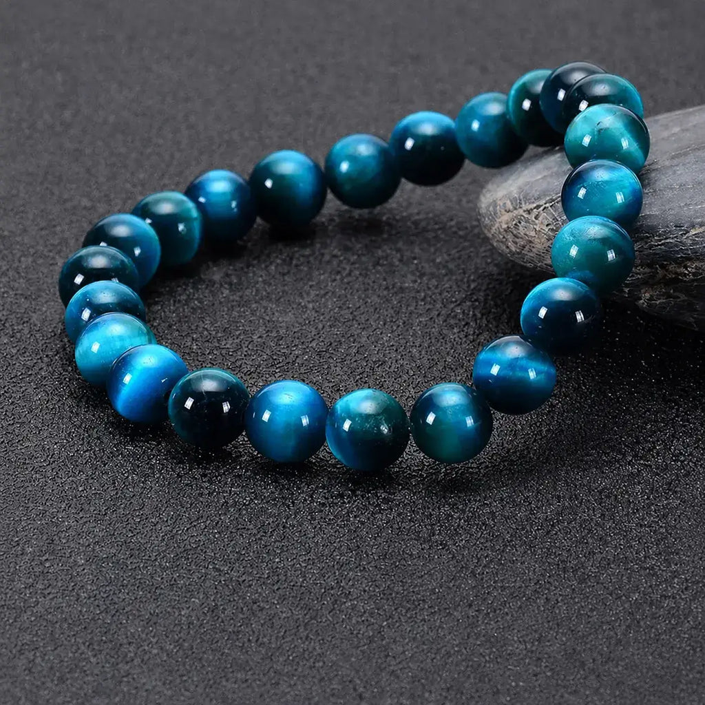 Side Angle View of Mariv Stones Blue Tiger Eye Bracelet with Natural Gemstone Beads on Elegant Dark Background.