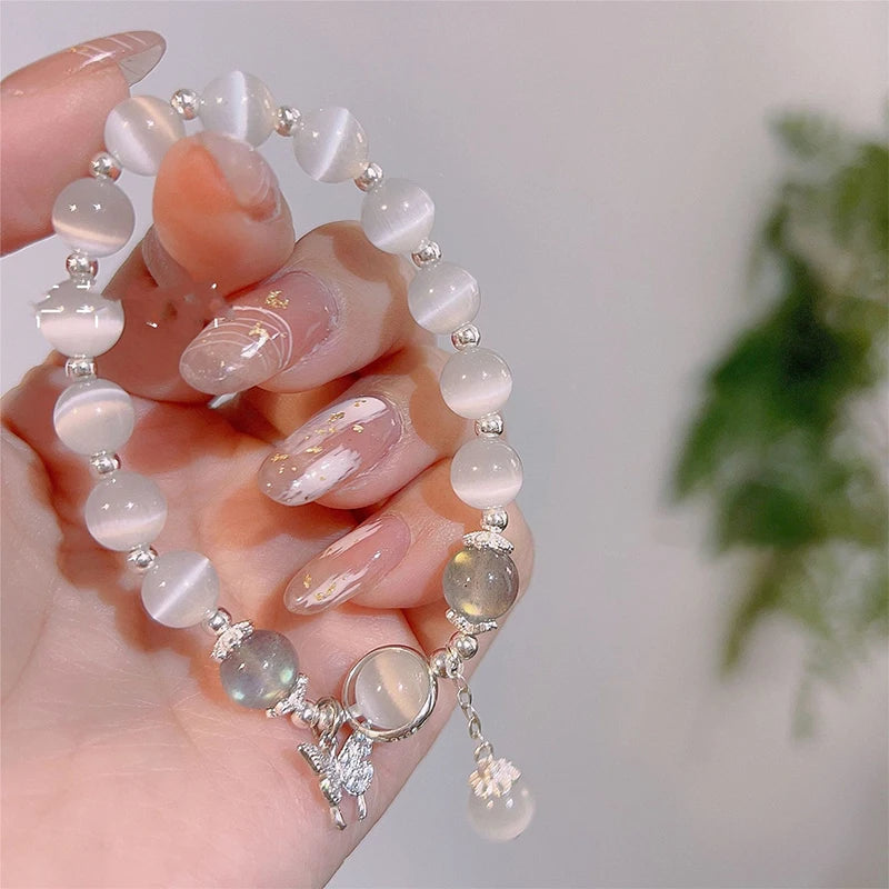 Delicate butterfly charm moonstone bracelet lifestyle shot on wrist.