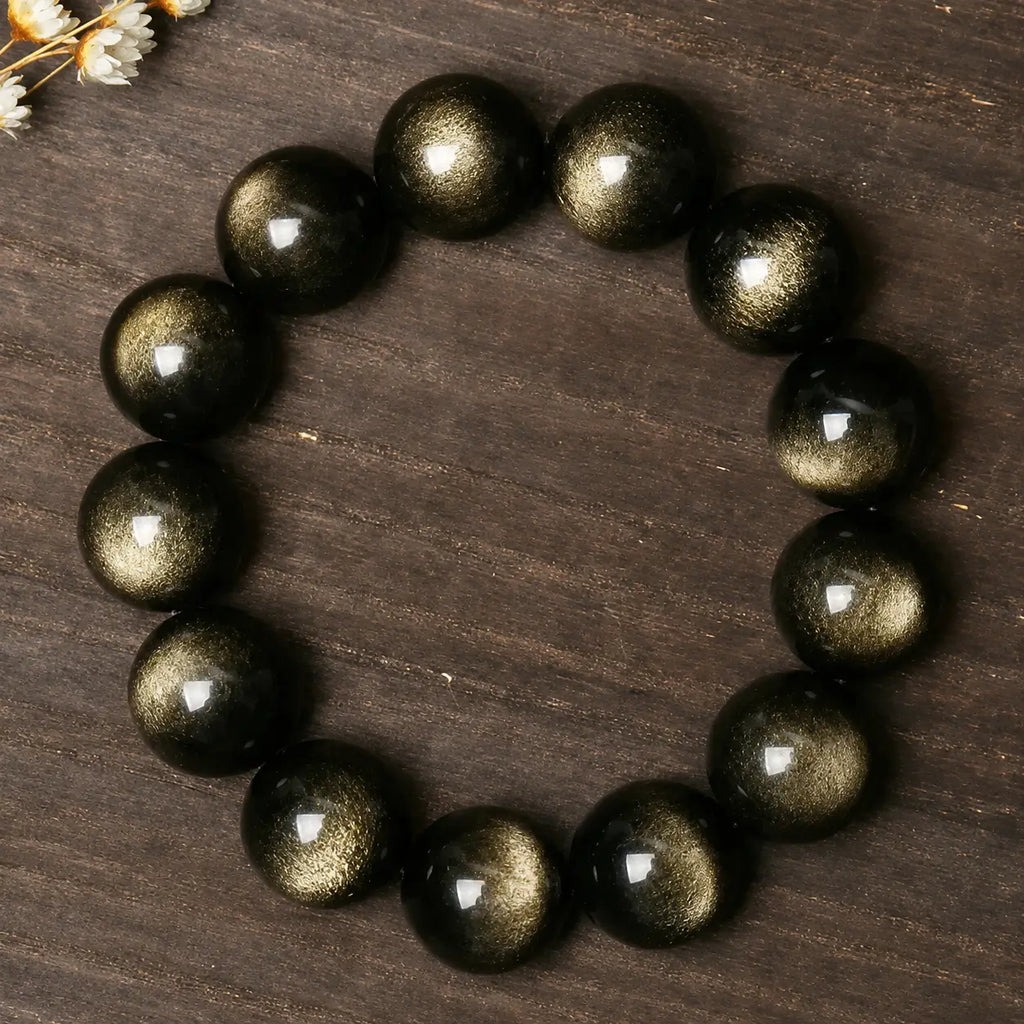 Natural Gold Sheen Obsidian Bracelet on a wooden surface, showcasing rich golden reflections and grounding energy.