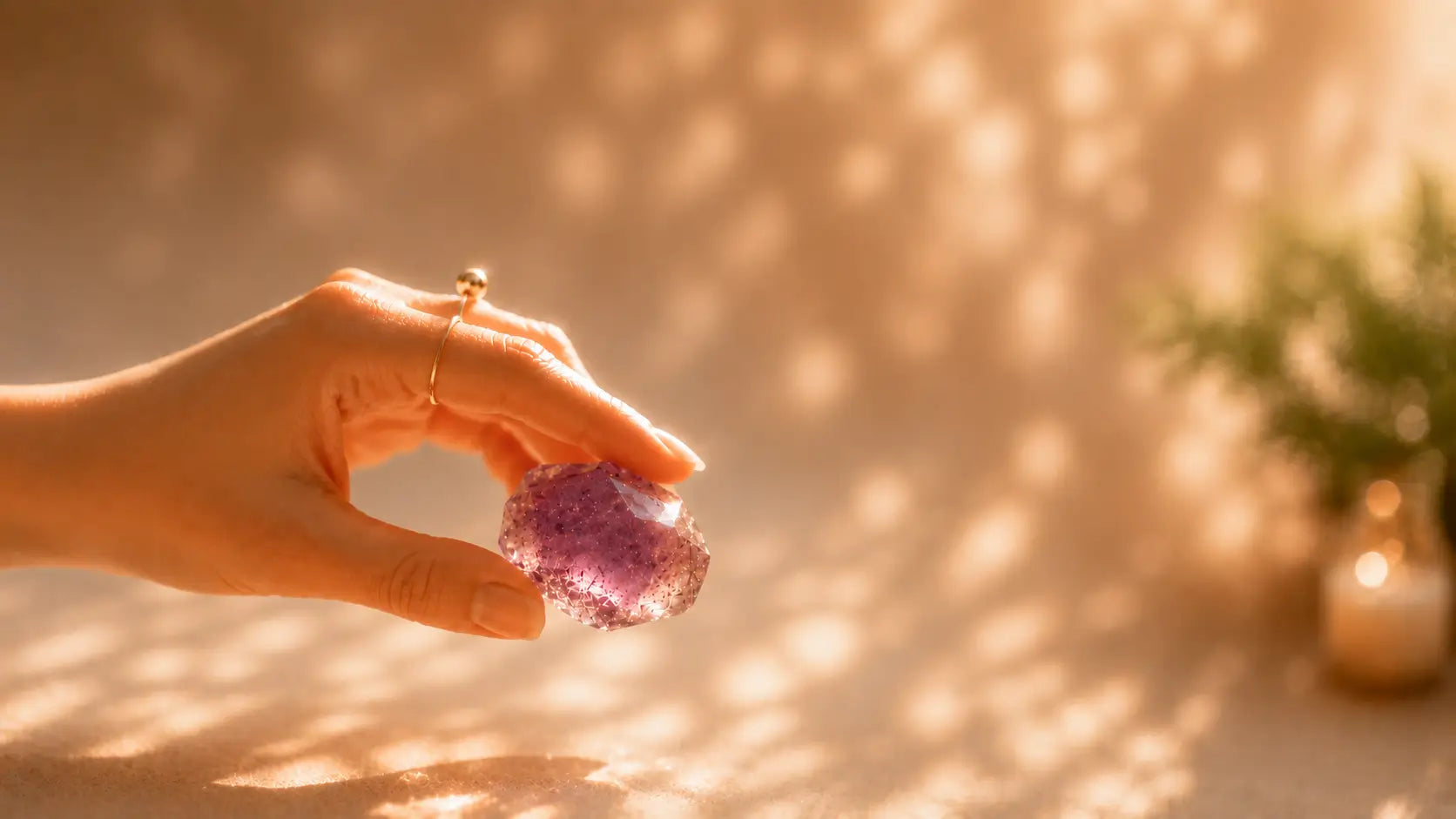 Hand holding natural amethyst crystal in warm sunlight, symbolizing calm energy, mindfulness, and emotional balance.
