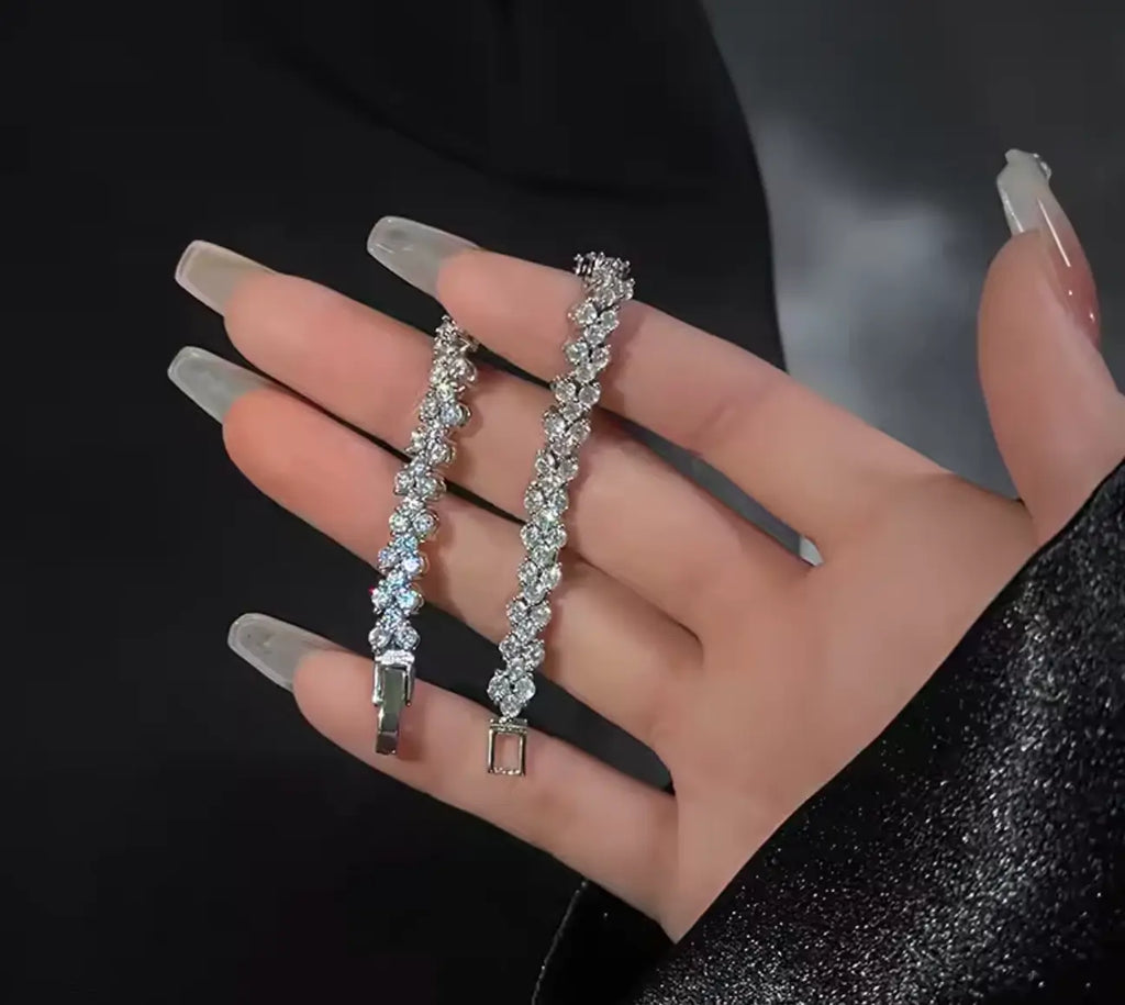 Elegant woman holding luxury crystal flower bracelets with glamorous fashion styling.