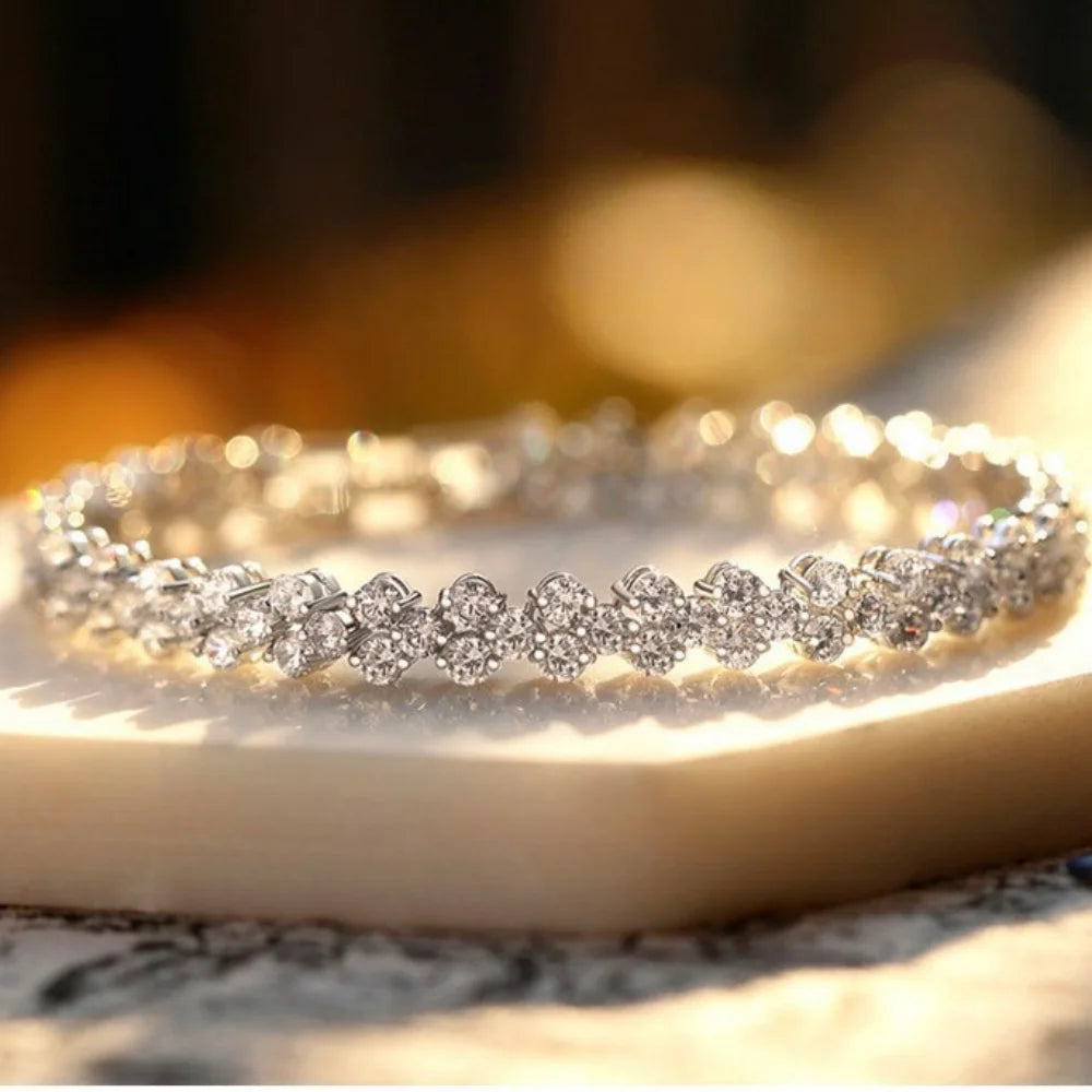 Sparkling floral crystal bracelet displayed in warm luxury lighting with elegant reflections.