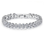 Luxury silver flower tennis bracelet with sparkling crystal stones on white background.