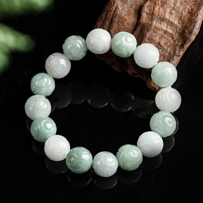 Close-up of lotus carved jade beads on wooden stand.