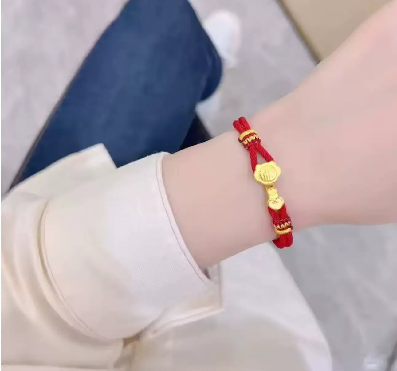 Customer photo: Red string bracelet with gold ruyi charm on wrist.