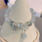Minimalist moonstone bracelet flatlay on aesthetic concrete prop.