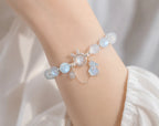 Delicate moonstone rabbit charm bracelet worn on female wrist for lifestyle.