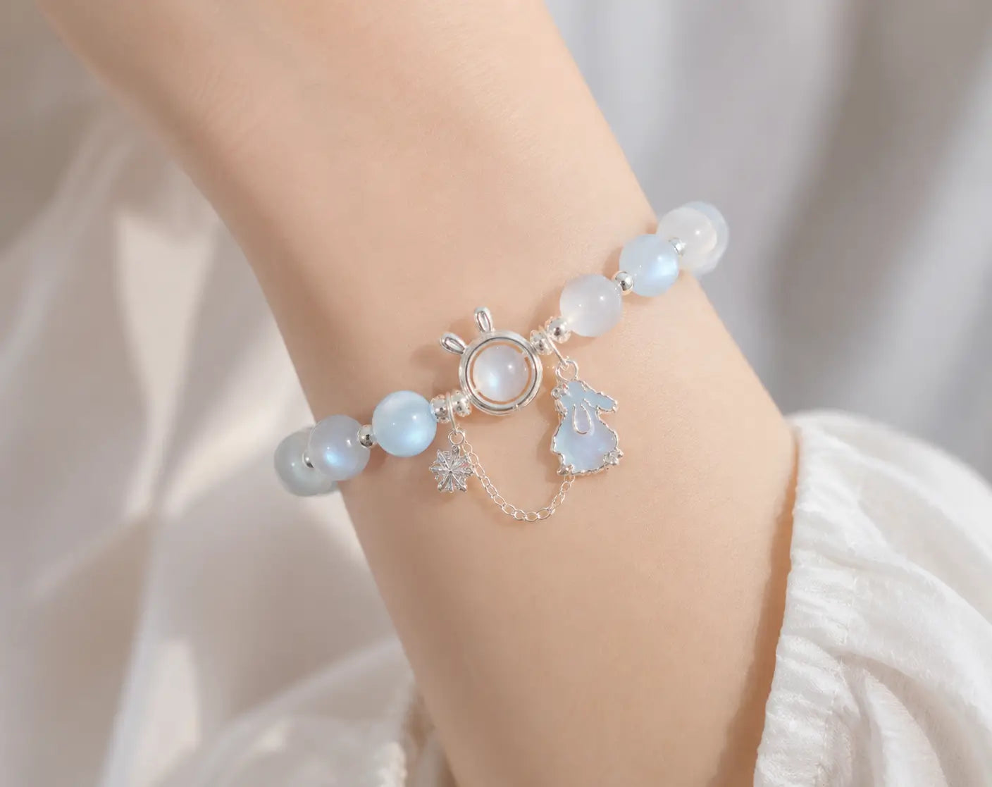 Delicate moonstone rabbit charm bracelet worn on female wrist for lifestyle.