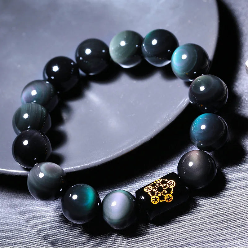 Rainbow Eye Obsidian Protection Bracelet displayed on a ceramic tray with rainbow sheen details.