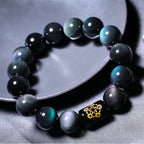 Rainbow Eye Obsidian Protection Bracelet displayed on a ceramic tray with rainbow sheen details.