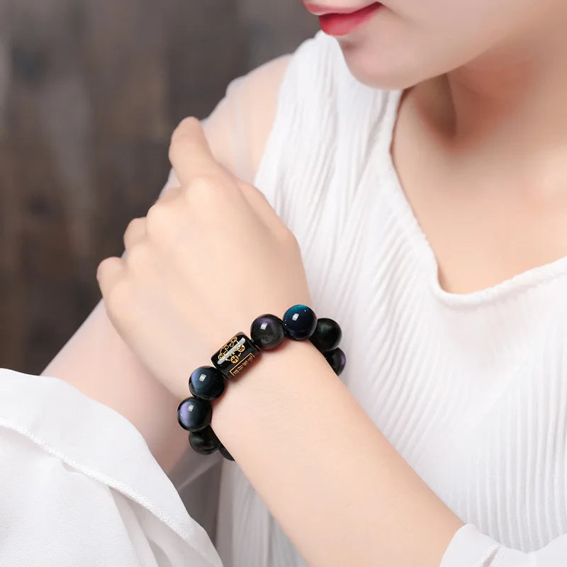 Rainbow Eye Obsidian Bracelet styled on the wrist with colorful natural obsidian reflections.