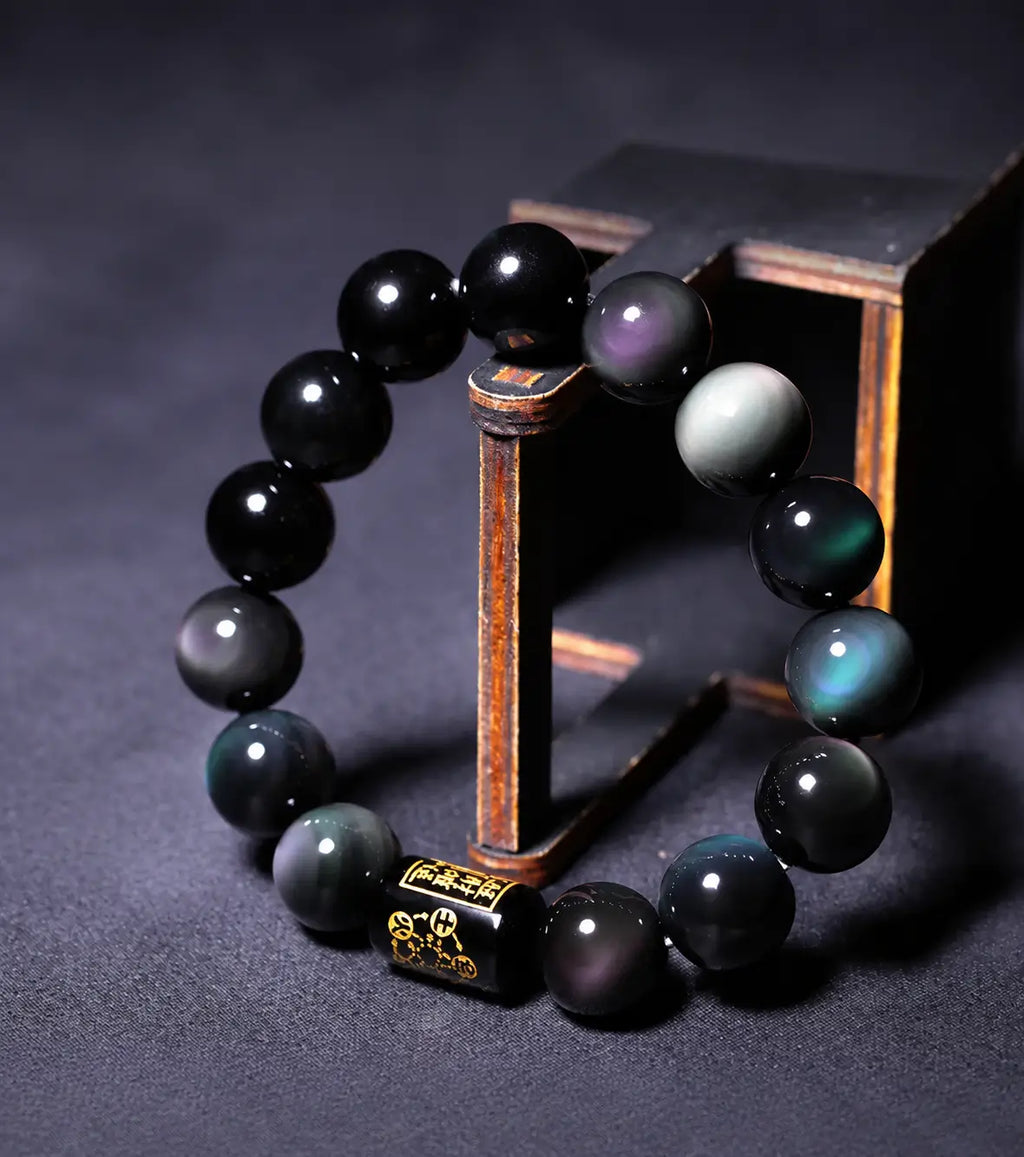 Rainbow Eye Obsidian Protection Bracelet with natural rainbow sheen beads and engraved center bead.