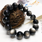 Natural Silver Sheen Obsidian Bracelet displayed with woven decor, featuring reflective gemstone beads and grounding energy.