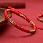 Adjustable Tibetan lucky knot bracelet featuring traditional five-color threads and handcrafted red cord for prosperity and protection