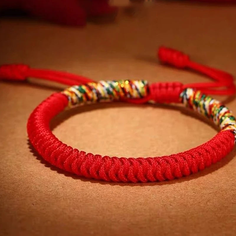 Tibetan lucky knot bracelet photographed in warm lighting, highlighting handcrafted weaving and auspicious five-color threads