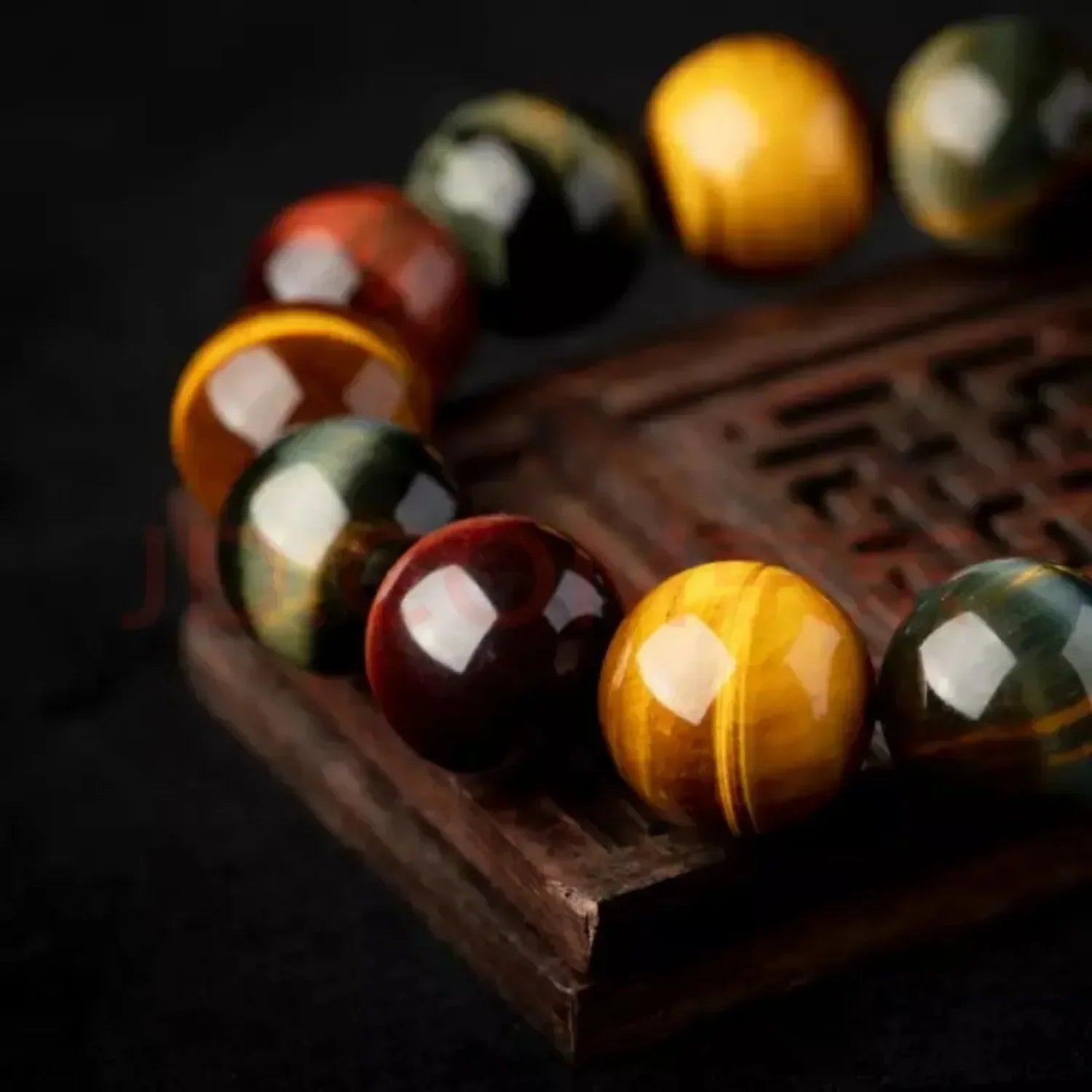 Close-up of polished triple tiger eye crystal bracelet with glossy gemstone texture and luxury dark background.