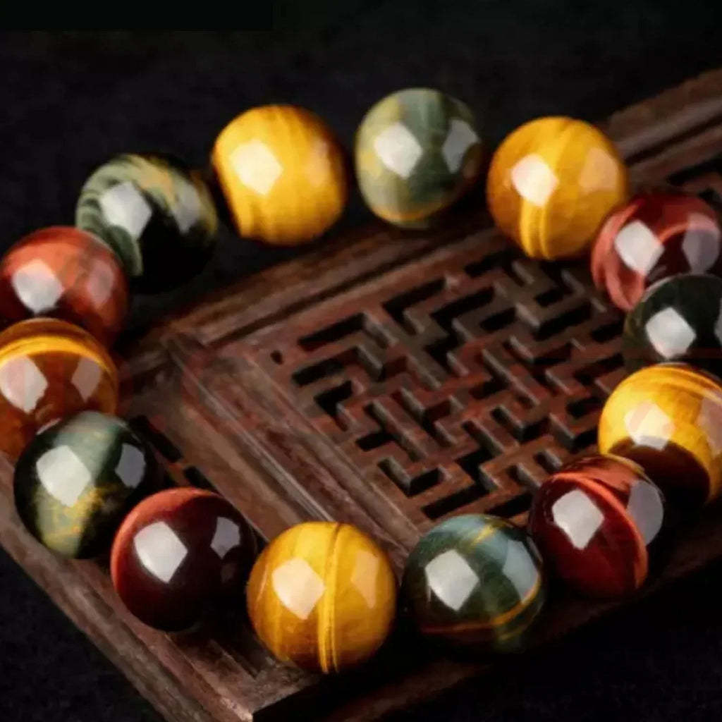 Triple tiger eye healing bracelet displayed on natural shell with spiritual meditation aesthetic.